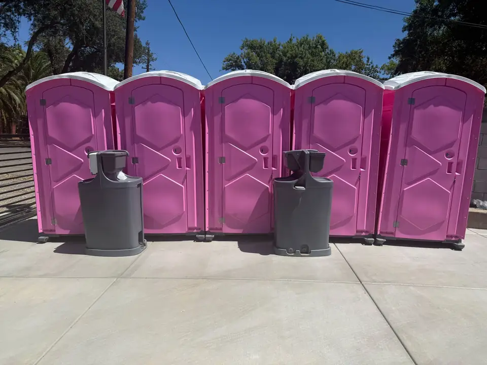 Row of pink event porta potties with two hand wash stations